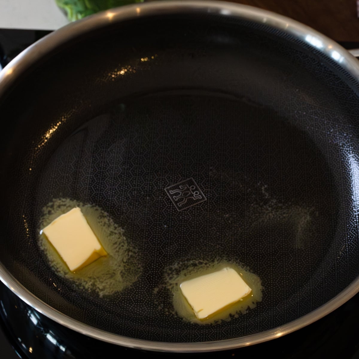 Butter melting in a hot skillet to start chicken sisig