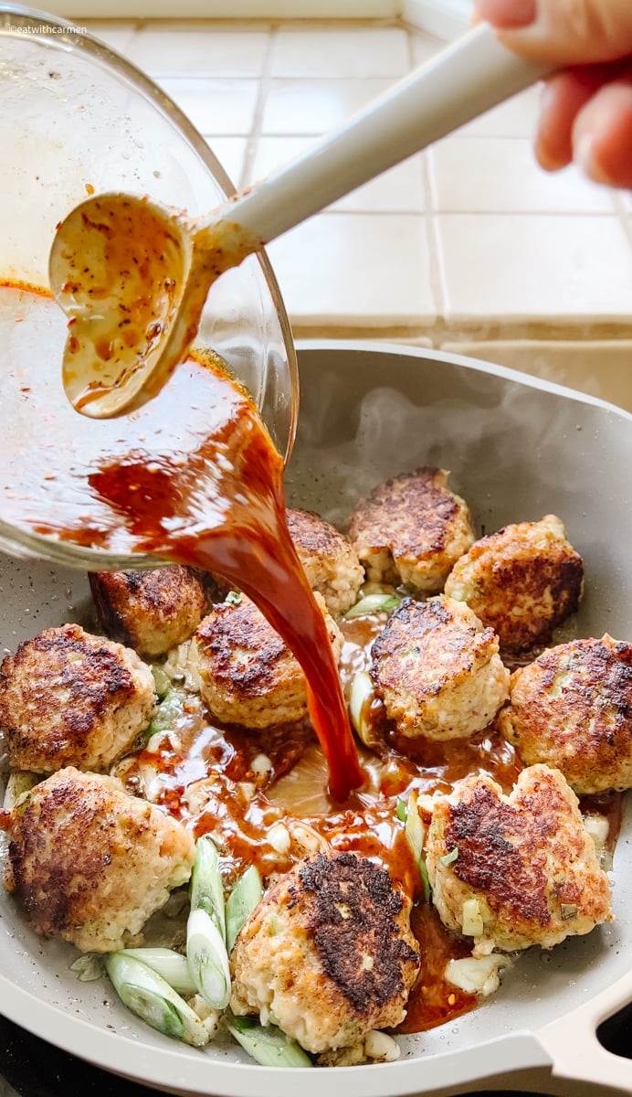 pour orange sauce for meatballs