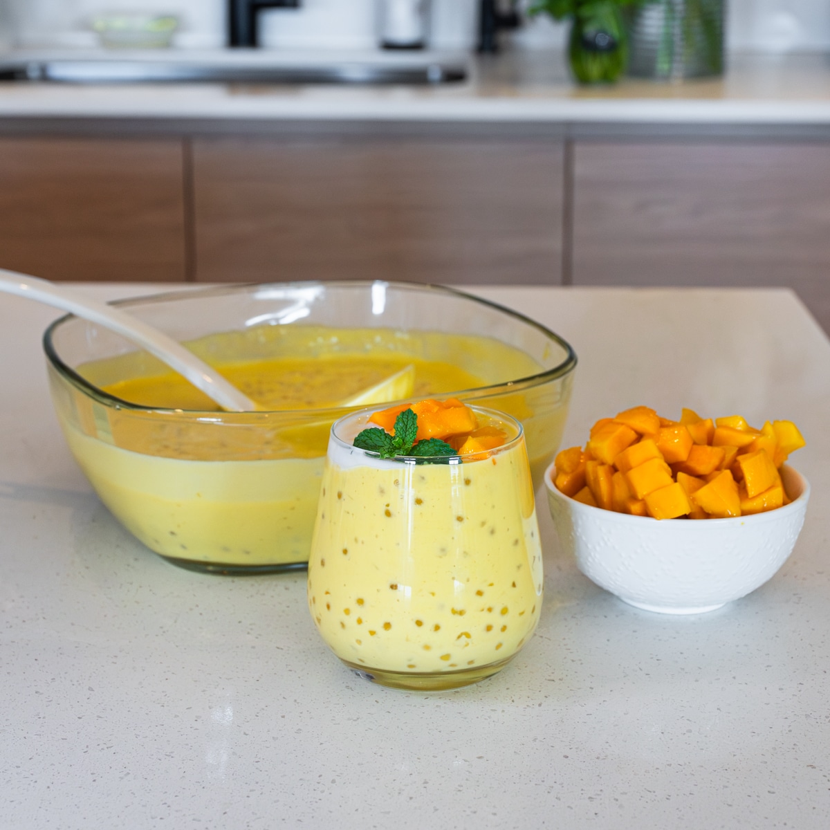 A glass of chilled mango sago topped with fresh mango