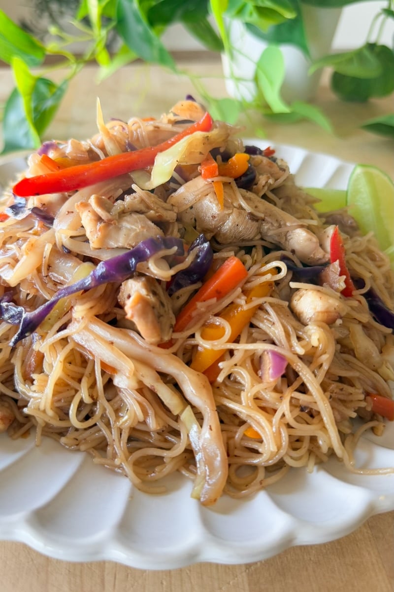chicken pancit with lime wedges.
