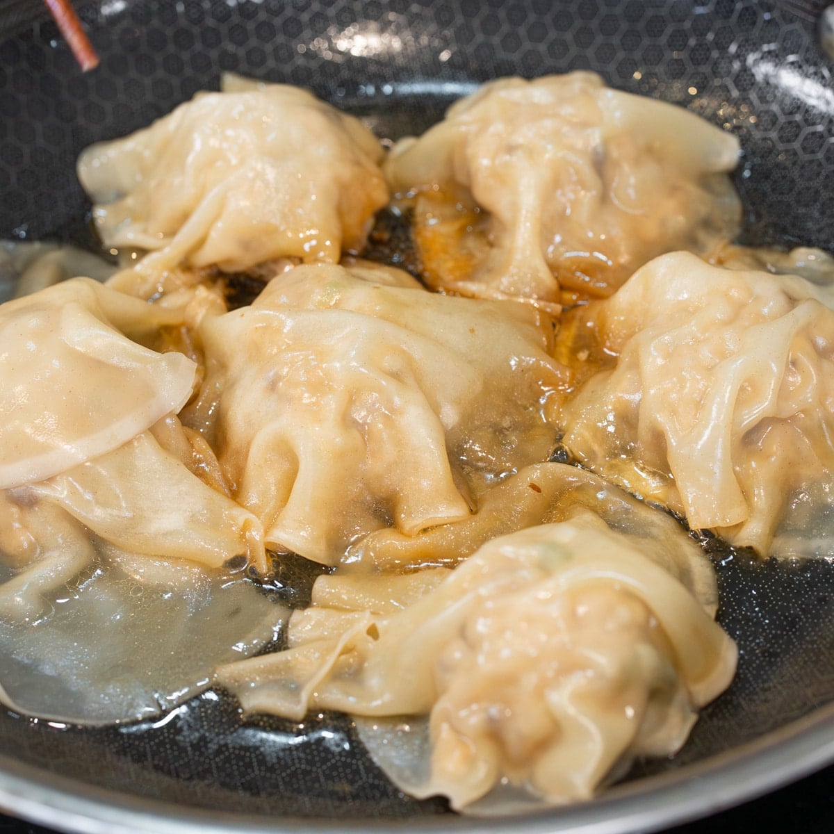 adding water to pan to steam no fold dumplings