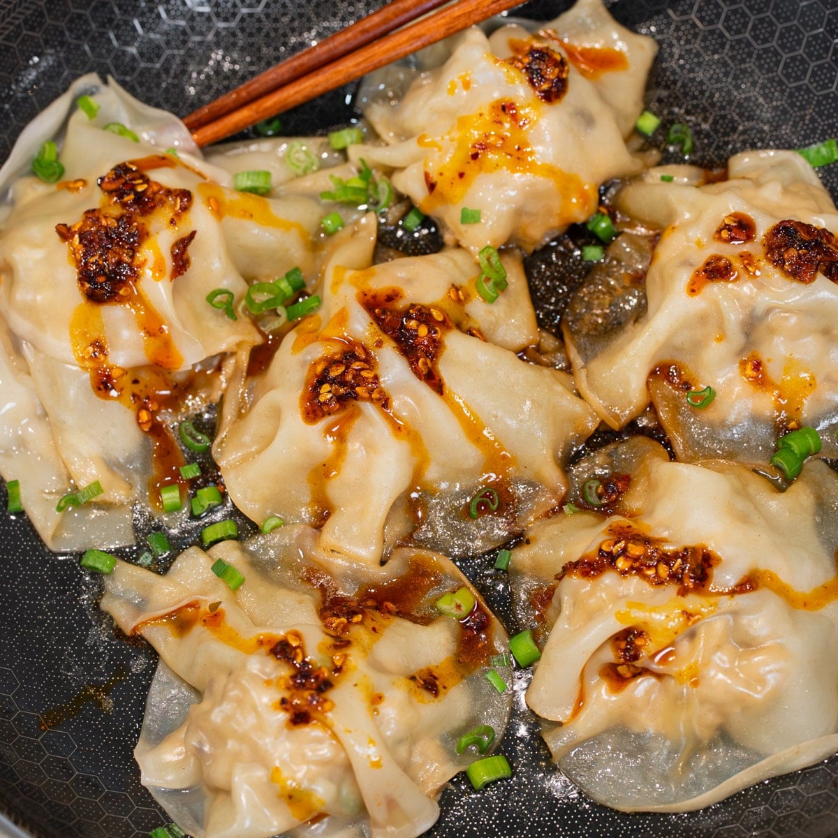 garnishing finished no fold dumplings with green onion and homemade dumpling sauce