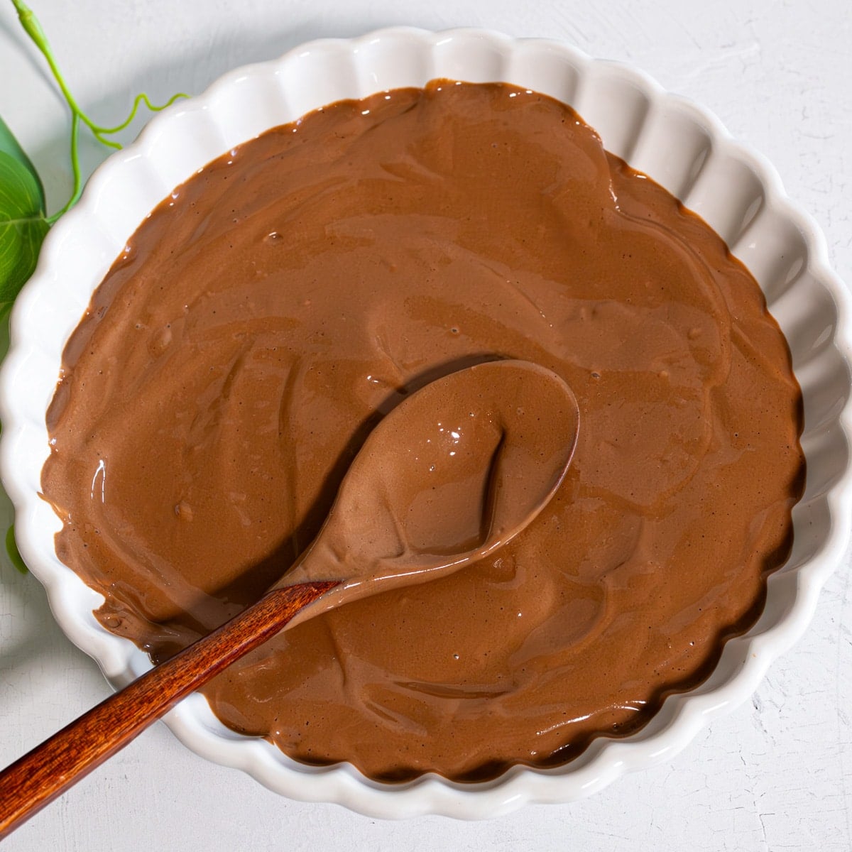boiled egg chocolate pudding in a bowl with wooden spoon showing consistency