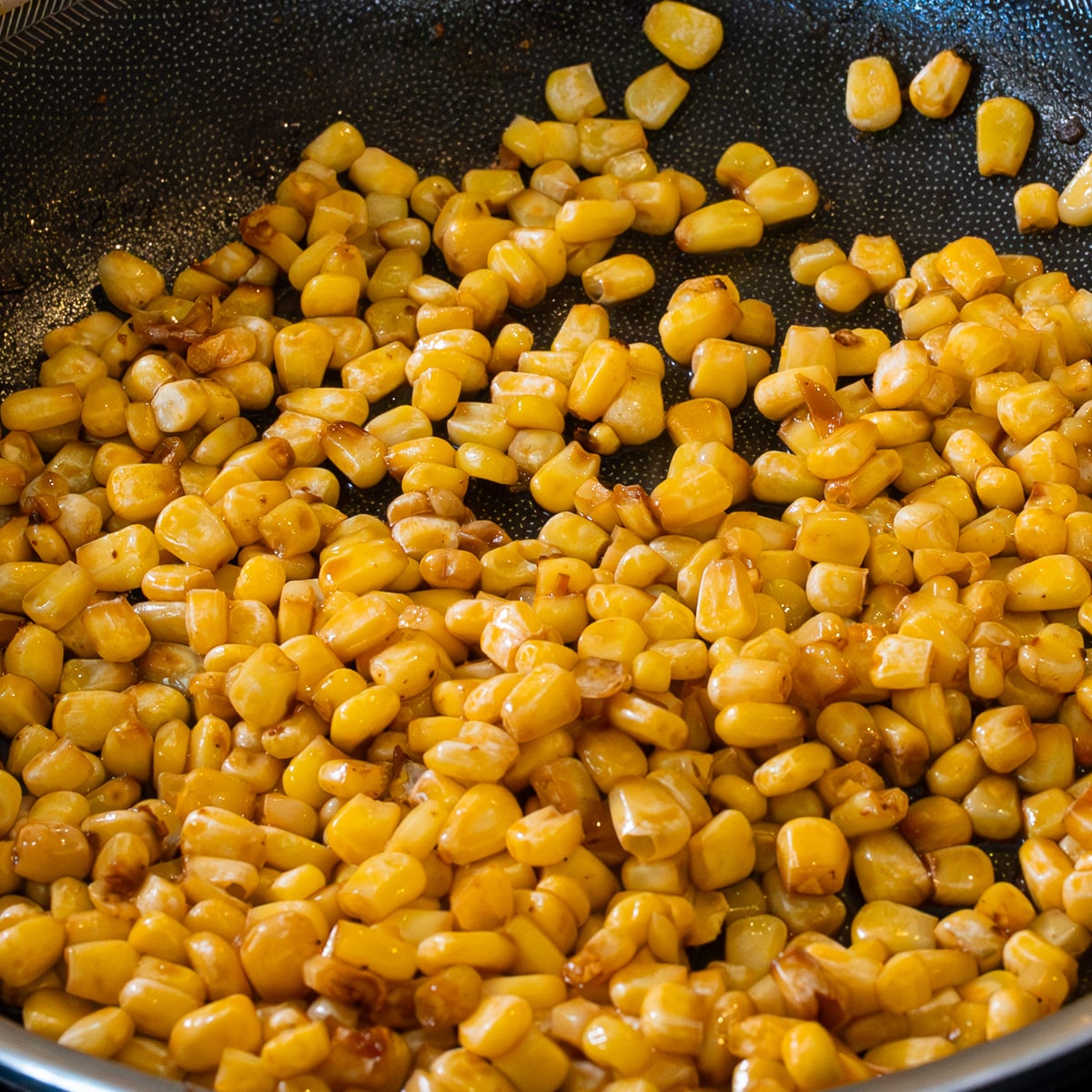 Frozen corn caramelizing in butter in a pan until golden for chicken miso ramen topping