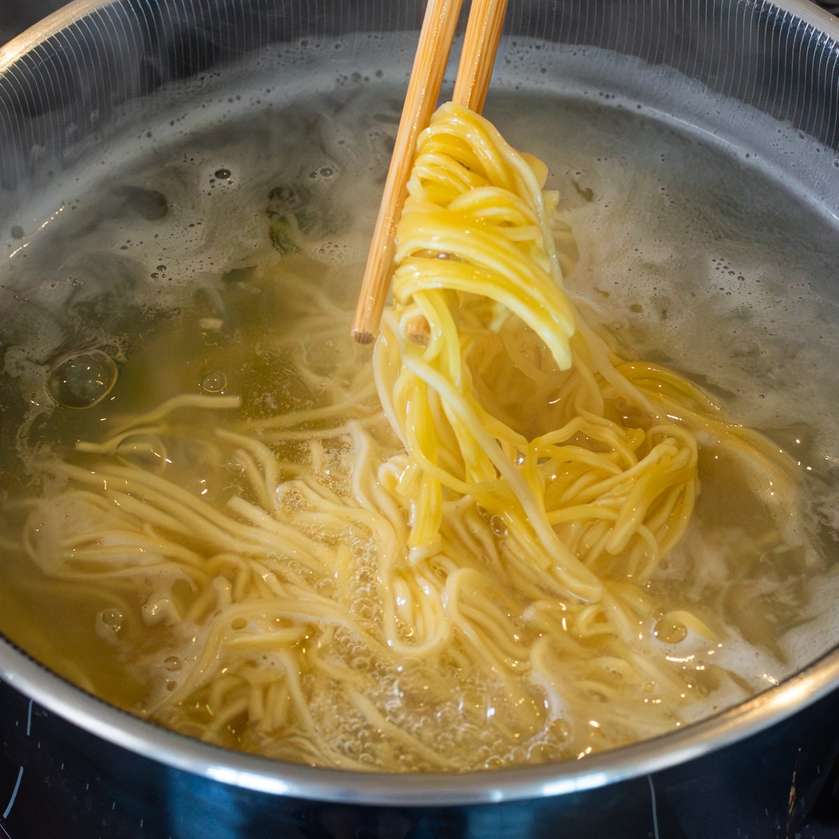 Fresh ramen noodles cooking in boiling water for 2 minutes for chicken miso ramen