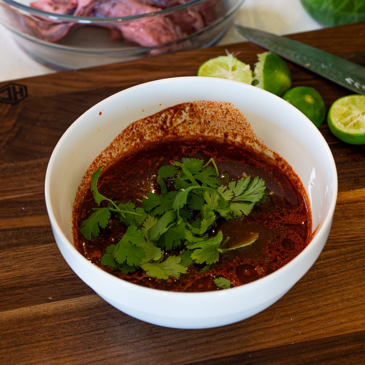 Asian skirt steak marinade with soy sauce, honey, sriracha, lime juice, and fresh cilantro in a white bowl