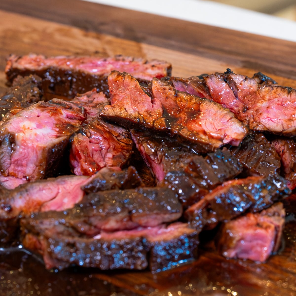 Asian marinated skirt steak rested and sliced thinly against the grain showing pink medium-rare centre